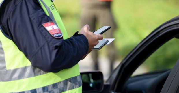 Ein Polizist kontrolliert die Identität eines Autofahrers.