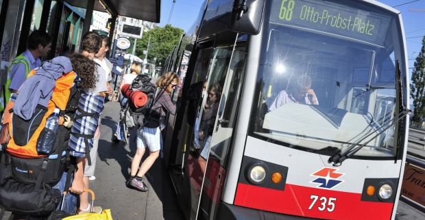 Rucksacktouristen steigen in Wien in eine Straßenbahn ein