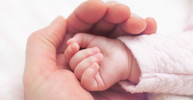 Babyhand in Hand der Mutter
