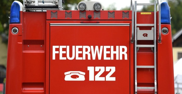 Rückseite eines roten Feuerwehrautos mit Notrufnummer