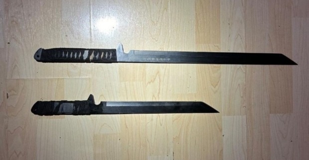 Zwei Macheten auf Holztisch liegend