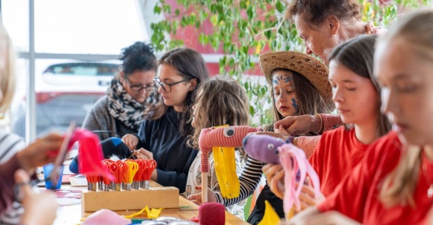 Gruppe von Kindern sitzt bastelnd am Tisch