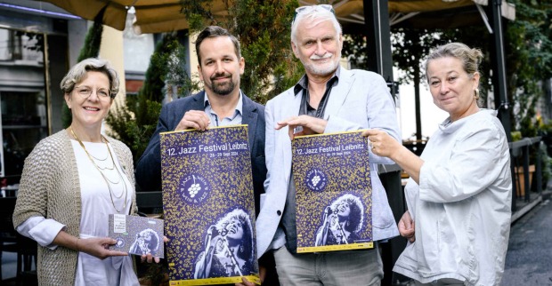Zwei Männer und zwei Frauen halten Plakate hoch