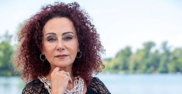 Mausi Lugner mit Perlenketten blickt ernst in die Kamera.