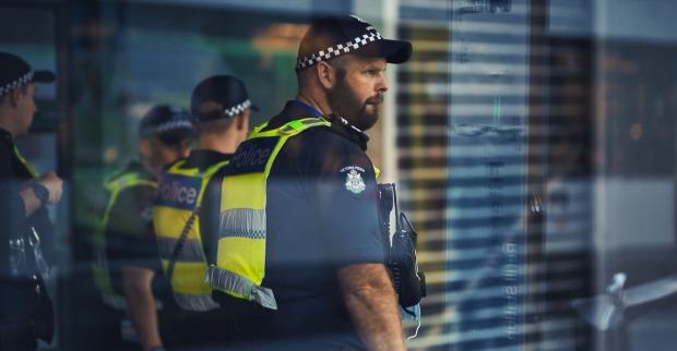 Australische Polizeibeamten hinter einer Glasfront.