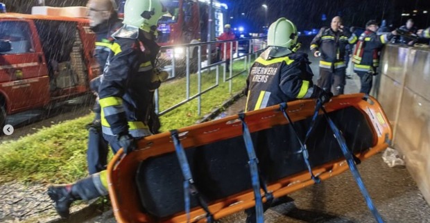 Einsatzkräfte der Freiwilligen Feuerwehr Krems eilen dem Rollstuhlfahrer mit einer Trage zu Hilfe.