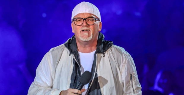 DJ Özi steht auf der Bühne mit Mikro in der Hand