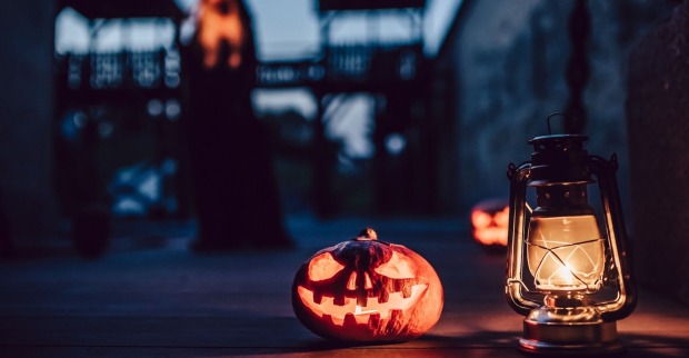 Ein Halloween-Kürbis und eine Laterne in der Nacht.