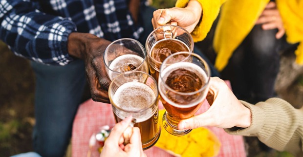 Vier Menschen halten ein Glas in der Hand und stoßen an