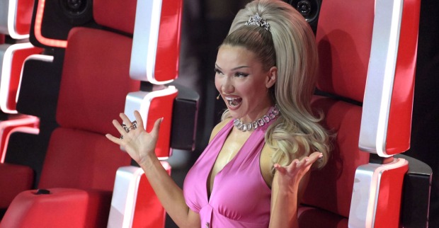Blonde Frau im pinken Outfit sitzt auf einem roten Sessel