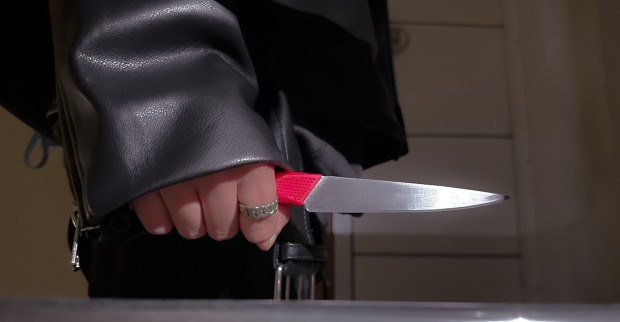 Eine Frau in einer Lederjacke mit einem Messer.