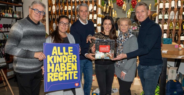 Mehrere Menschen halten ein Plakat und eine Spendenkiste