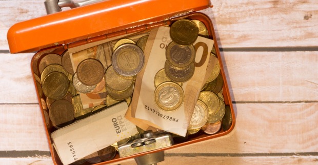 Euro-Scheine und -Münzen in einer orangen Dose.