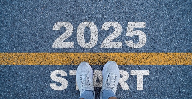 Schriftzug "2025 Start" und Sportschuhe auf einer Straße.