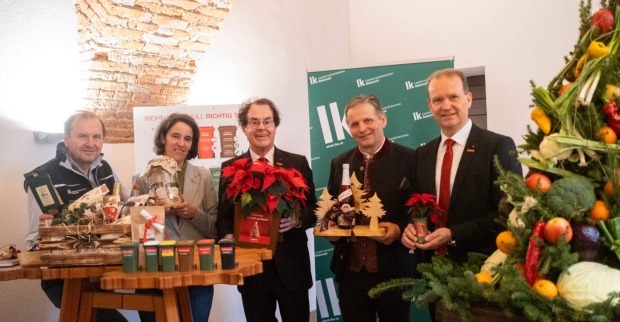 Mehrere Menschen stehen rund um einen Tisch