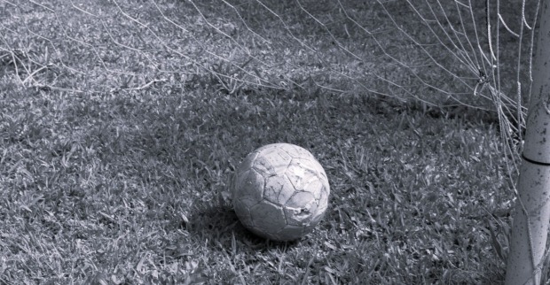 Fußball auf Platz im Tor liegend