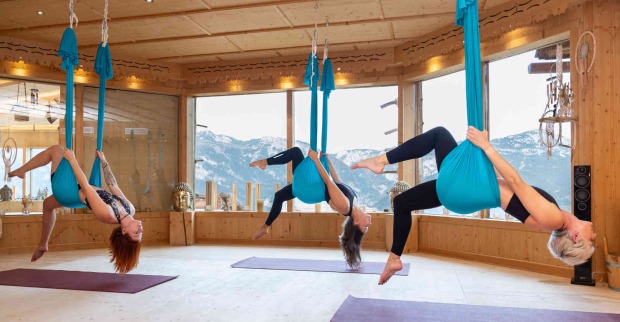 Frauen machen Aerial Yoga in blauen Tüchern