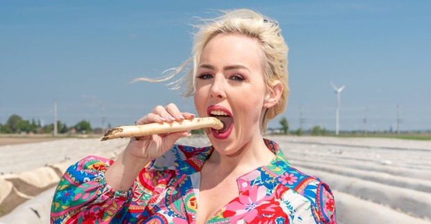 Lydia Kelovitz beißt in einen Spargel.