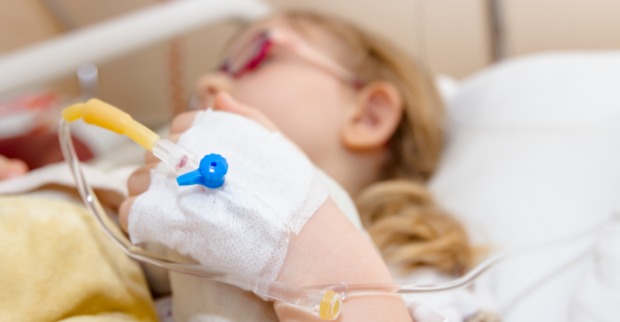 Ein kleines Mädchen liegt in einem Krankenhausbett.