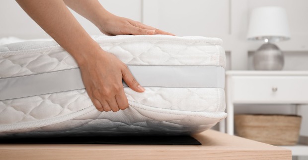 Frau legt Matratze auf Lattenrost | Credit: iStock.com/Liudmila Chernetska