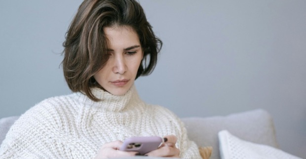 Frau blickt auf ihr Handy