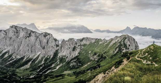 Bergpanorama mit einsamen Wanderer auf einem Alpinpfad