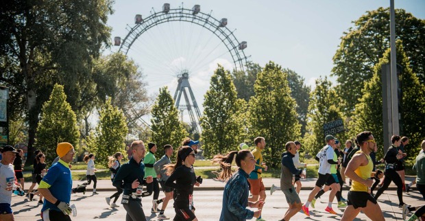 Teilnehmer des Vienna City Marathons mit dem Riesenrad im Hintergrund