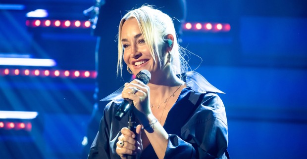 Blonde Frau singt in ein Mikrofon