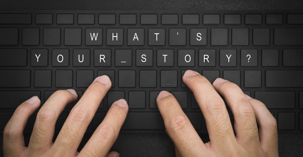 Zwei Hände tippen auf einer Tastatur, wo "What's your Story?" draufsteht.