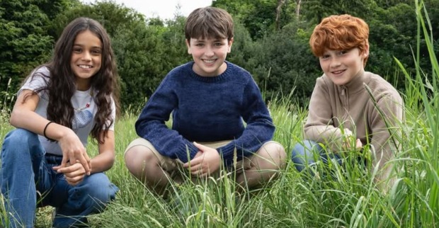 Die neuen Harry Potter-Hauptdarsteller knien im Gras: Arabella Stanton, Dominic McLaughlin and Alastair Stout