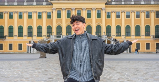 Ein Mann steht vor einem gelben Schloss