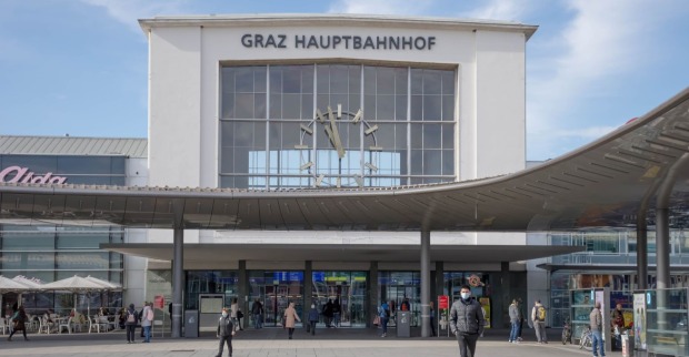Vorderseite des Grazer Hauptbahnhofs bei Tageslicht – Menschen vor dem Gebäude.