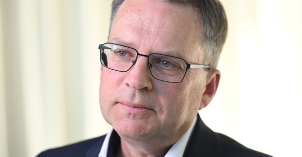 Porträt von August Wöginger, der eine Brille trägt und ernst in die Kamera blickt.