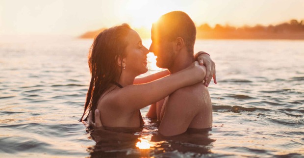 Eine Frau und ein Mann umarmen sich im Wasser