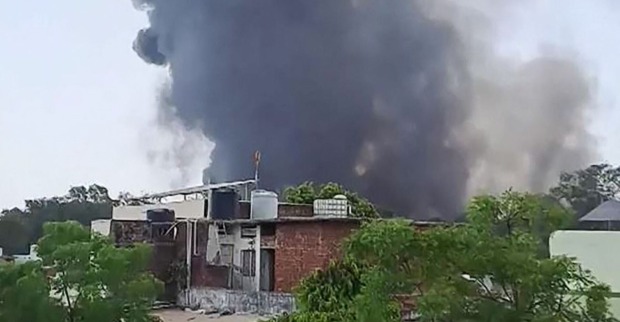 Schwarzer Rauch steigt hinter flachen Wohnhäusern in den Himmel, nachdem ein Flugzeug der Air India nahe dem Flughafen von Ahmedabad abgestürzt ist.