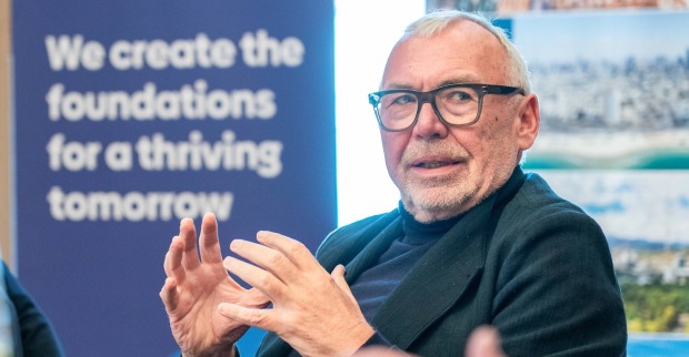 Alfred Gusenbauer spricht gestikulierend bei einer Veranstaltung, im Hintergrund ein Poster mit dem Schriftzug „We create the foundations for a thriving tomorrow“.