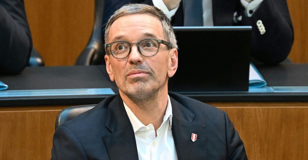 Herbert Kickl im Anzug mit Brille sitzt nachdenklich im Nationalrat.