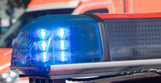 Blaulicht eines Polizeifahrzeugs im Einsatz, unscharf im Hintergrund ein Einsatzfahrzeug.