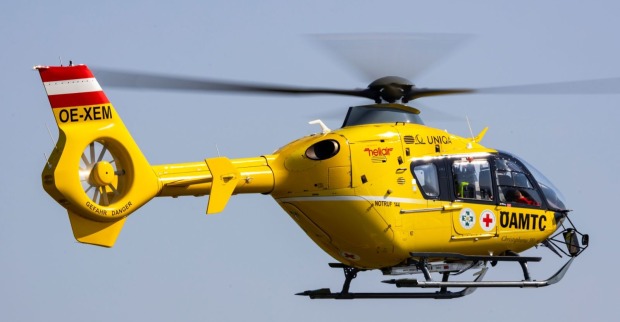 gelber Hubschrauber des ÖAMTC im Einsatz in der Luft