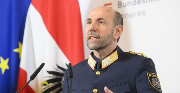 Franz Ruf in Uniform bei einer Pressekonferenz, im Hintergrund österreichische und EU-Flagge.