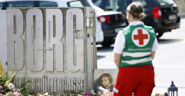 Eine Mitarbeiterin des Roten Kreuzes steht vor dem Eingang des BORG Monsbergergasse in Graz, wo Blumen und Kerzen nach dem Amoklauf niedergelegt wurden. Die Tat erschütterte ganz Österreich.