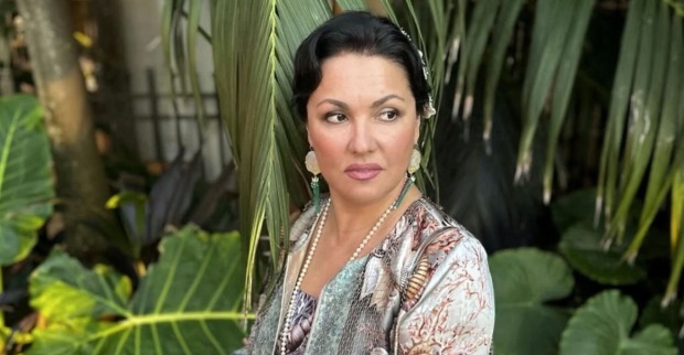 Anna Netrebko mit Pflanzen im Hintergrund