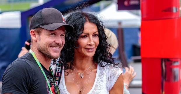 Felix Baumgartner lächelt neben Mihaela Schwartzenberg, beide stehen eng beieinander bei einem Event im Freien.