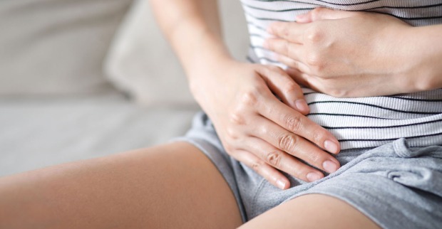 Frau hält sich Bauch vor Schmerzen | Credit: iStock.com/Rattankun Thongbun