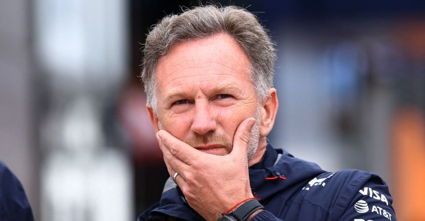 Christian Horner mit nachdenklichem Gesichtsausdruck, die Hand am Kinn, in Red-Bull-Teamkleidung.