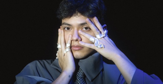 Sänger JJ hält die ringbesetzten Finger an seine Gesichtswangen