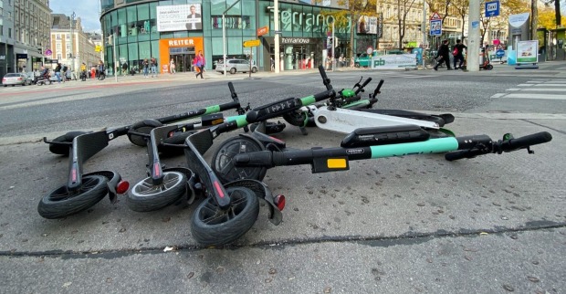 E-Roller verschiedener Leihdienste liegen auf der Wiener Mariahilfer Straße