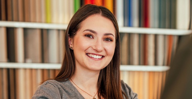 Junge lächelnde Frau im Büro | Credit: iStock.com/Chanakan Phinakan