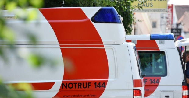 In der Reihe stehende Rettungswägen des Roten Kreuz auf einem Parkplatz
