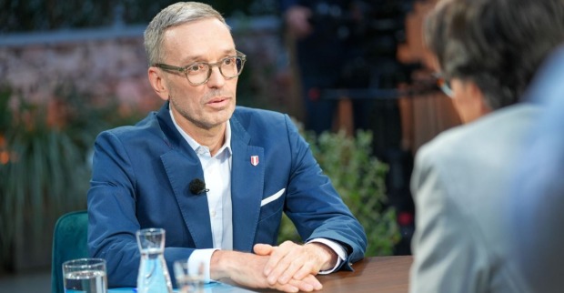 Herbert Kickl sitzt im ORF-Sommergespräch an einem Tisch, trägt Brille und blauen Anzug, spricht mit Moderator Klaus Webhofer.